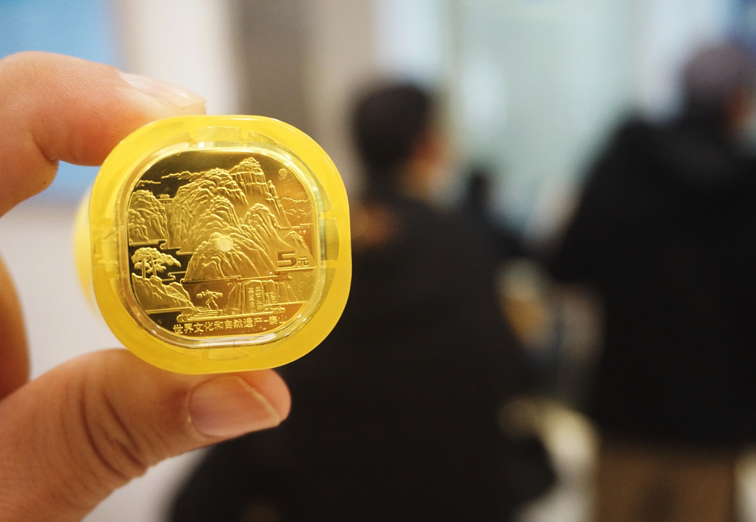 中国首枚异形纪念币“泰山币”发行 市民排队兑换